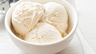 un bol avec trois boules de glace vanille dedans