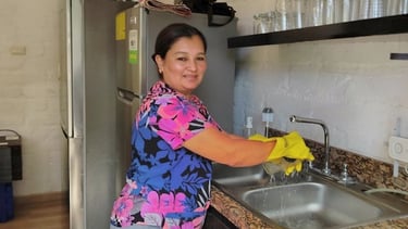 a woman in a blue shirt is cleaning a kitchen