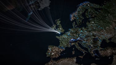 Overhead wide-angle map view of fiber route lines tracing across a dark topographic surface connecting North America to Europe, cool blue accent lines on a near-black background, no text or labels visible, minimal and technical