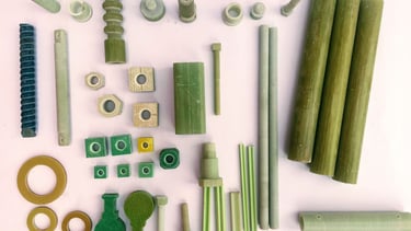 Collection of green industrial fiberglass reinforced plastic FRP bolts, nuts, and structural components.