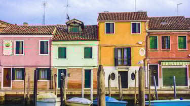 Imagen de casas coloridas en Italia frente a un canal.