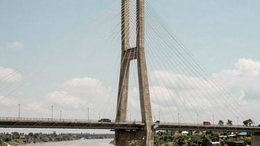 Photography of a newly constructed modern suspension bridge over a South American river valley, showing the symmetry and scale of the engineering feat.