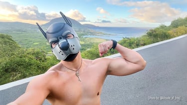 A shirtless man in a pup mask flexing and posing on Hawaii vista. @kitsune_of_troy