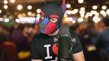 Man in pup mask standing at a microphone