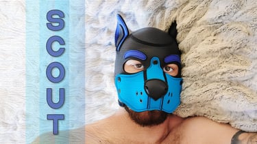 A man in a pup mask, with a name plate: SCOUT