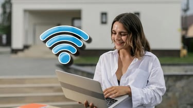 Mujer feliz usando laptop con señal WiFi excelente tras aplicar consejos de MBTECNIC.