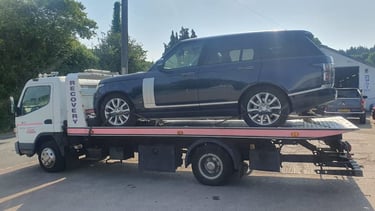a car being towed down a street in a parking lot