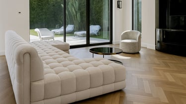 Modern living room with tufted beige sofa, round coffee table, and large glass doors to patio