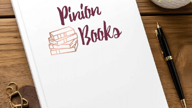 book cover that reads pinion books laying on a table.