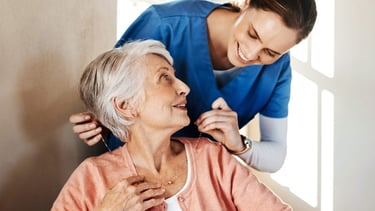 Operatrice di assistenza domiciliare che aiuta una signora anziana