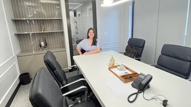 a woman sitting at a table with a phone in front of her