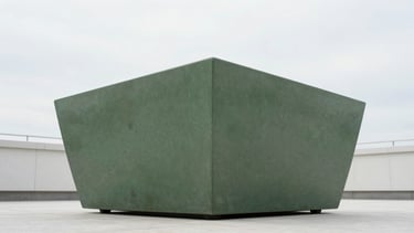 Low-angle perspective of a massive monolithic planter on a modern rooftop terrace, soft overcast sky, structural precision