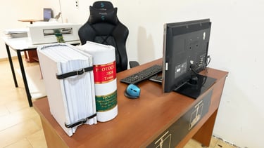 Escritorio de oficina con encuadernaciones de protocolo, monitor de computadora