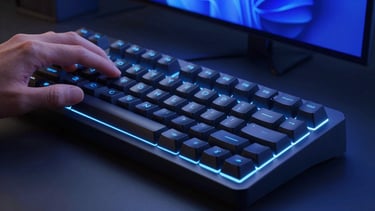 Sleek close-up of hands using a modern mechanical keyboard in low-light, ambient electric blue glow from screens