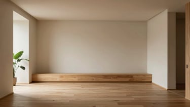 Wide shot of a minimalist, light-filled architectural interior with soft shadows, natural oak wood, and a single green plant in the foreground, evoking calm and mental breathing room. Soft, indirect daylight.