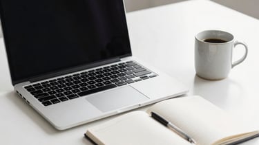 A high-end, minimalist photography of a creative studio desk in a North American / US office setting. A silver laptop, a clean white notebook, and a ceramic mug sit on a bright white surface. Soft, natural morning light creates a professional yet approachable mood. The composition is clean and premium, emphasizing a modern workflow.