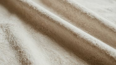 Extreme close-up of high-end tactile fabric texture, heavy-weight organic linen, soft directional natural light with deep shadows, warm bone and espresso tones, 35mm film