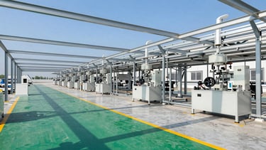 Wide environmental shot of a clean, modern manufacturing plant floor with green safety walkways and structured overhead lighting, sharp focus
