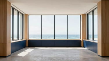 Wide, quiet coastal office interior in Sarasota, bright natural daylight filtered through high windows, minimalist design with warm wood and navy accents