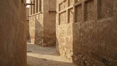 Warm editorial photography of a quiet, narrow stone alleyway in an ancient Middle Eastern quarter at golden hour. Soft natural side-light casting deep shadows on textured plaster walls. No people, rich earthy tones, 35mm film texture, shallow depth of field.