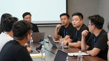 A collaborative meeting between brand representatives and influencers discussing campaign ideas.