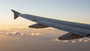 The clean geometry of a modern aircraft wing slicing through a sea of golden clouds during sunset, crisp and elegant composition.