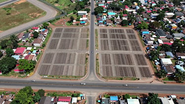 Overhead drone photograph in bright neutral daylight showing the Sulur township road grid, demarcated plot boundaries clearly visible, Coimbatore airport perimeter fencing in the upper-left corner, NH-544 highway running horizontally across the lower third, scale giving clear sense of proximity