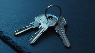 Macro close-up of physical security keys on a dark slate surface, cold blue LED glow, 35mm lens