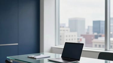 A clean, modern professional office interior in North American / US. Minimalist workspace with white walls and deep navy accents. A high-end glass desk sits in front of a window overlooking a blurred cityscape. Natural light pours in, highlighting a premium laptop and a sleek notepad. The atmosphere is sophisticated and successful.