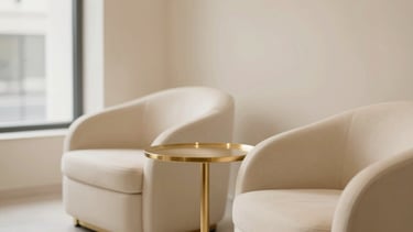 Clean minimalist salon interior, featuring a comfortable waiting area with soft cream upholstery and a subtle gold accent table, diffused natural window light from the left, shallow depth of field.