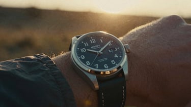 Moody close-up of a premium timepiece on a rugged outdoor expedition, dramatic golden hour backlighting, cinematic film grain.