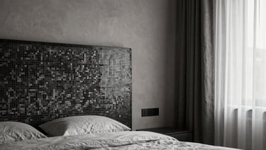 A modern minimalist bedroom suite with a monochromatic palette, featuring a custom mosaic headboard detail and sheer linen curtains, European elegance.