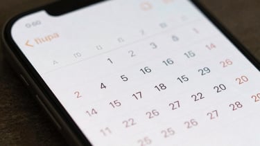 Close-up of a high-resolution smartphone display showing a creative calendar interface with soft typography, soft morning light, East Asian / Japanese aesthetic.