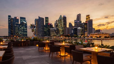 A private terrace overlooking the futuristic skyline of Singapore at dusk, warm ambient lighting, luxury atmosphere, 35mm