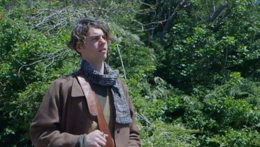 a man in a brown jacket and scarf