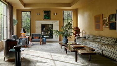 Kelly Wearstler living room with a couch and a table and large fireplace.