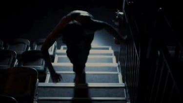 a man walking up stairs in a darkened room