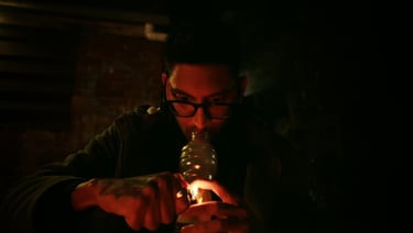 a man in a black jacket is holding a bottle of beer