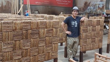 Jiwo standing in front of a large group of headboard weaved by banana fiber