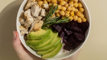 a person holding a bowl of food with avocado