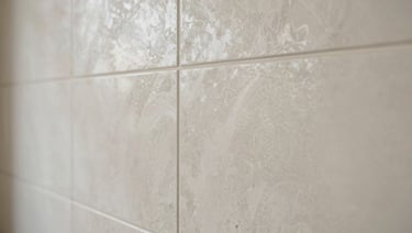 Close-up of a polished venetian plaster wall, subtle bone-white reflections, elegant and smooth architectural finish.