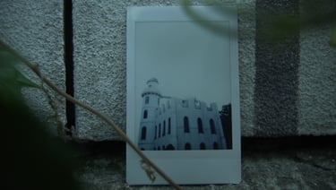 Photograph of a white castle placed against a stone wall, still from Nostalgia by Tina Bikic.