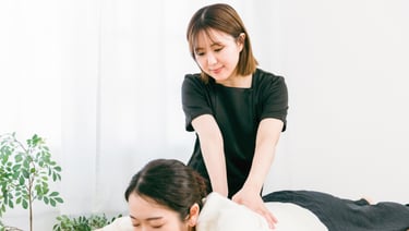 女性セラピストがベッドで横になる利用者に全身もみほぐしを行っている様子｜堺市のニュースならサカイタイムズ