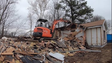a excavator is parked in front of a demoed house