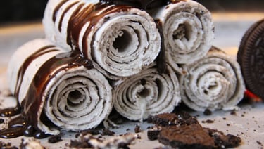 Handmade rolled ice cream with chocolate drizzle and crushed chocolate cookies.