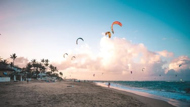 a beach with people flying kites and kites cabarete beach dominican republic