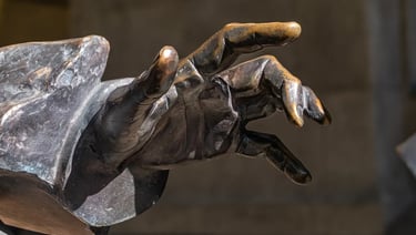Close-up of Georg Solti statue’s hand reaching forward, symbolizing guidance and brilliance.