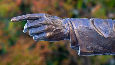 Close-up of George H. W. Bush statue’s outstretched hand, symbolizing diplomatic guidance.