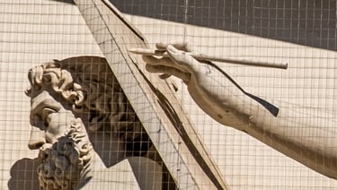 Close-up of the writing hand of the female statue representing History on the museum’s pediment.
