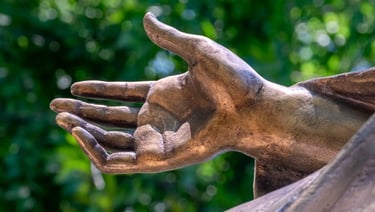 Close-up of the protective hand of Saint Barbara, showing sculpted details and gentle gesture.